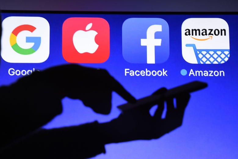 This photograph taken on Sept. 28, 2017, shows a smartphone being operated in front of Google, Apple, Facebook and Amazon logos.